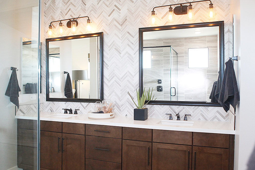 Custom framed mirrors in dark brown wood over a double bathroom vanity with light marble counters and dark walnut cabinets Hall of Frames Arizona