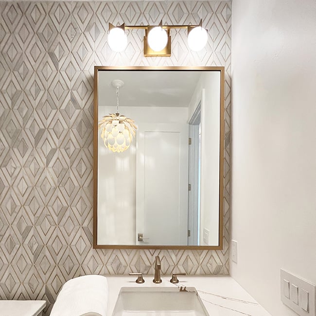 Photo of a custom framed gold bathroom mirror single sink Hall of Frames
