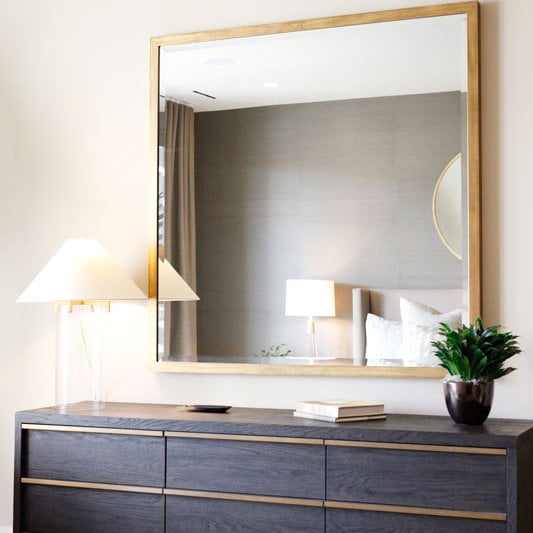 Photo of a custom framed floating beveled mirror in a bedroom