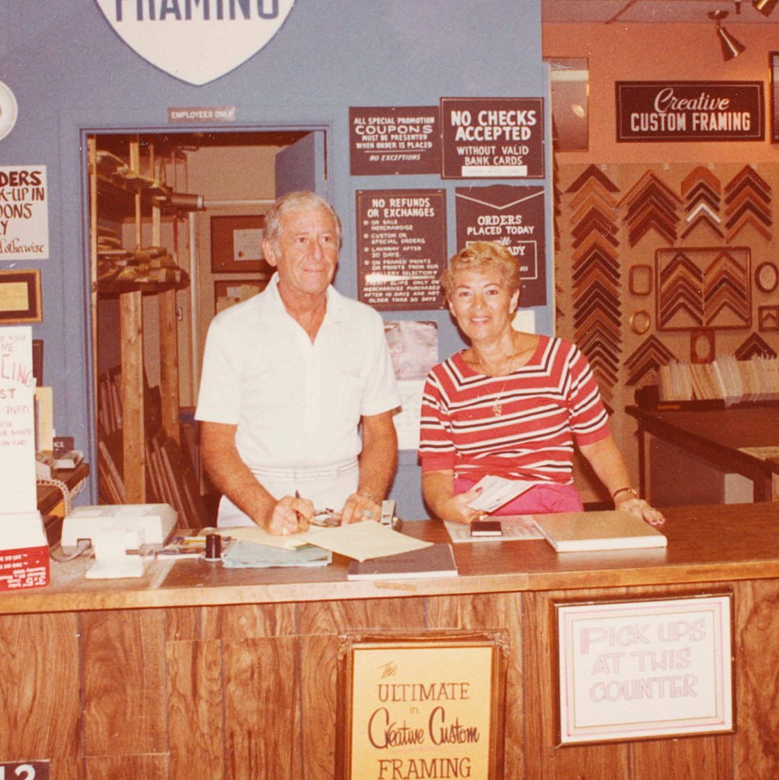 A photo of Ben and Evelyn Kogan at the counter of their first Hall of Frames store in 1975.