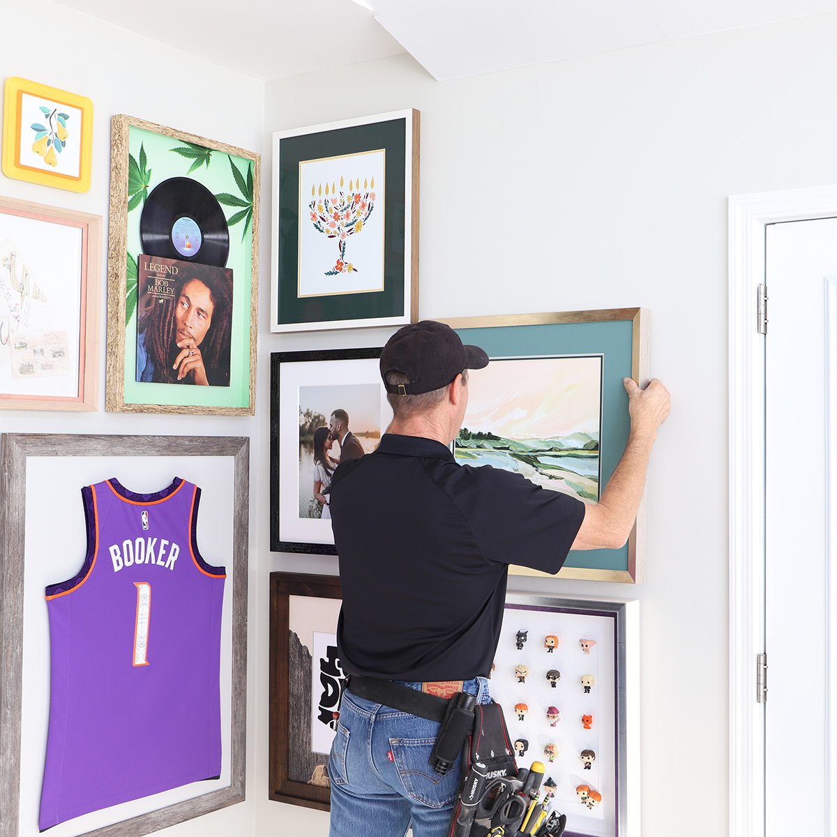 A photo of a Hall of Frames professional hanging pictures and framed objects