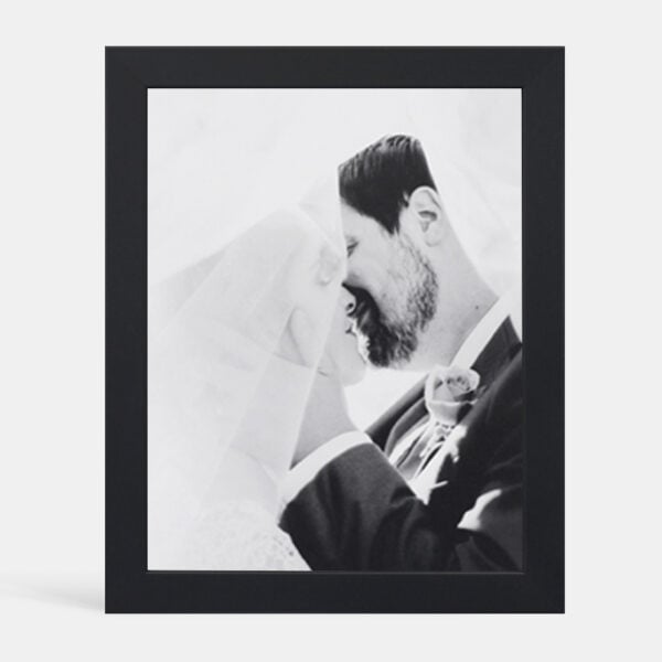 A custom framed photograph of a couple kissing on their wedding day, without a mat
