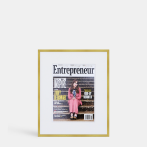 A photo of a custom framed cover of Entrepreneur magazine in a thin modern gold brass by Hall of Frames.
