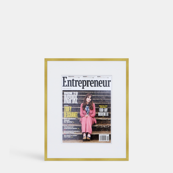 A photo of a custom framed cover of Entrepreneur magazine in a thin modern gold brass by Hall of Frames.