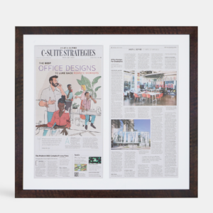 A photo of a custom framed newspaper two page spread article from Hall of Frames.