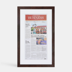 A photo of a custom framed newspaper article by Hall of Frames.