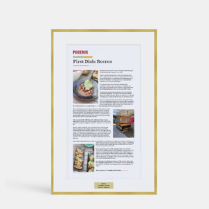 A photo of a custom framed large digital article with engraved plate in a thin modern gold brass by Hall of Frames.