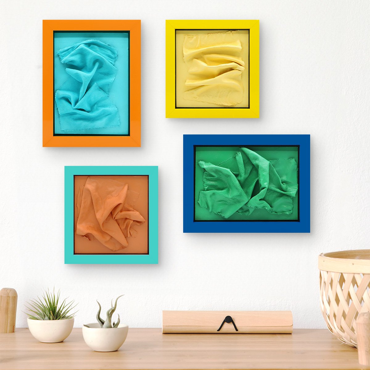 A photo of a colorful gallery wall with framed mixed media art.