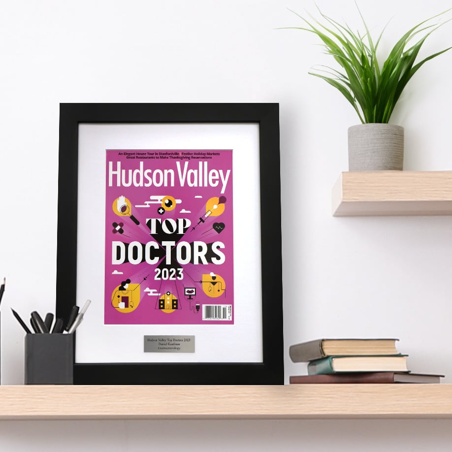 A photo of a framed Hudson Valley Magazine cover with a laser engraved plaque sitting on a shelf.