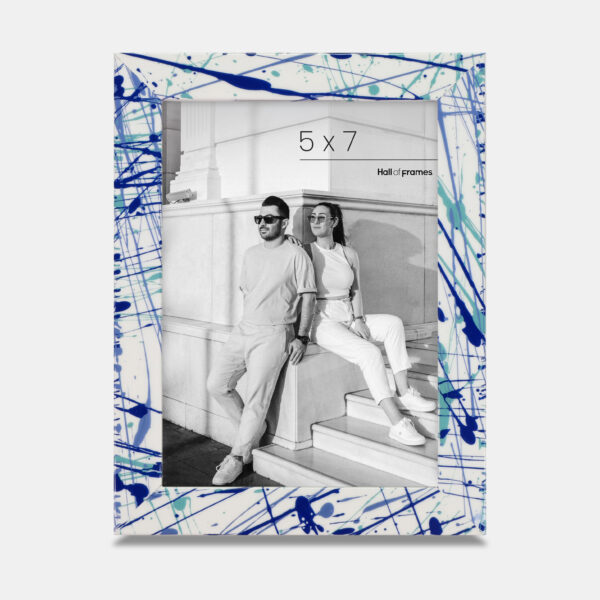 A paint splatter frame in the color Azure Flow featuring a modern, architectural photo of a couple.