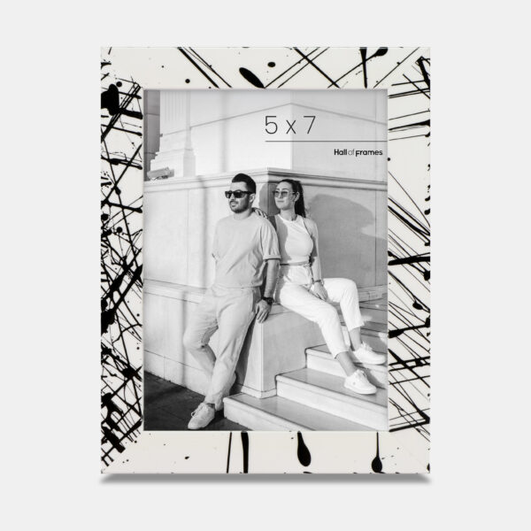 A paint splatter frame in the color Metro Fade featuring a modern, architectural photo of a couple. 