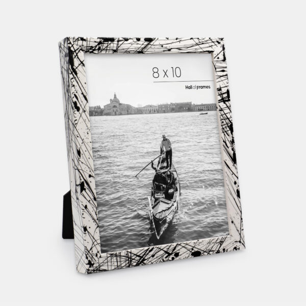 A paint splatter frame in the color Metro Fade featuring a photo of a couple in a gondola. 
