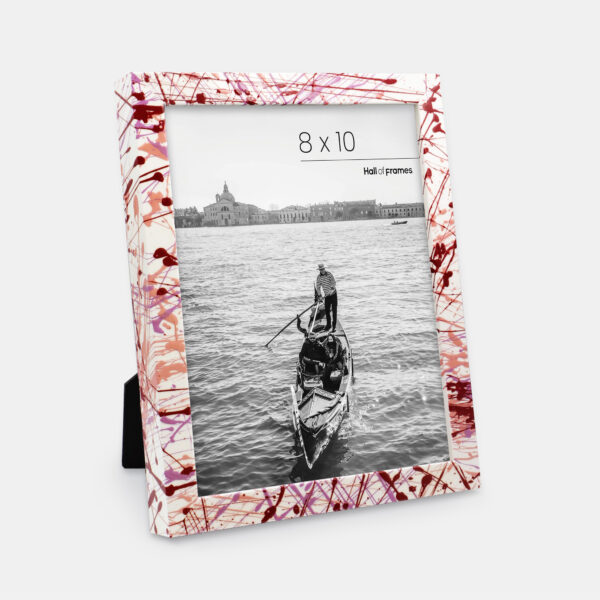 A paint splatter frame in the color Rebel Rose featuring a photo of a couple in a gondola. 