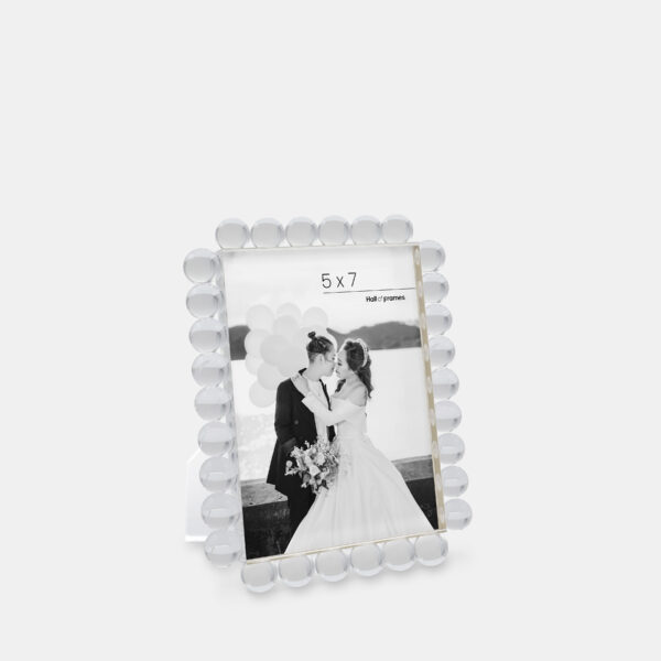 A 5x7 clear acrylic bubble frame that features a photo of a couple at a wedding.