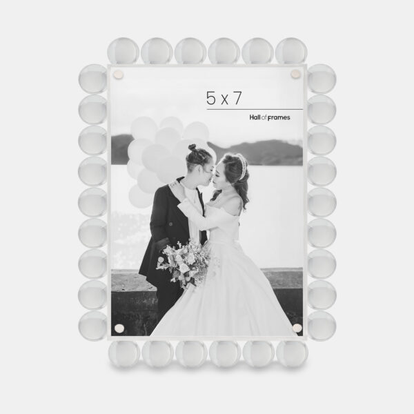 A 5x7 clear acrylic bubble frame that features a photo of a couple at a wedding.