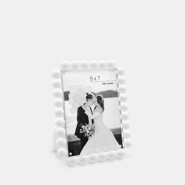A 5x7 white acrylic bubble frame that features a photo of a couple at a wedding.