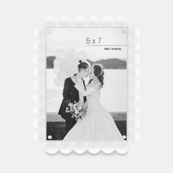 A 5x7 white acrylic bubble frame that features a photo of a couple at a wedding.