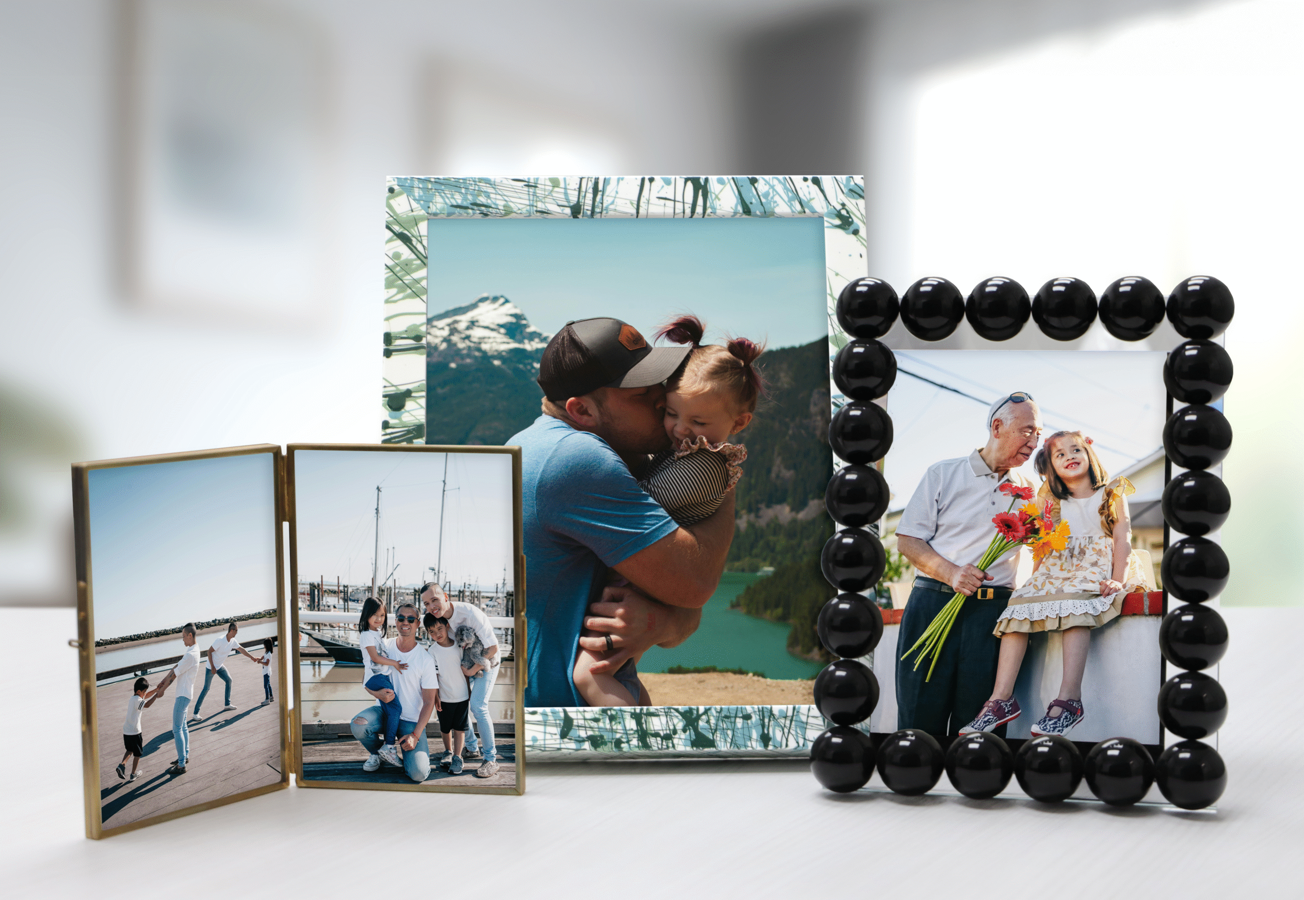 Tabletop frames of a gold frame, black bubble frame, and splatter paint frame.