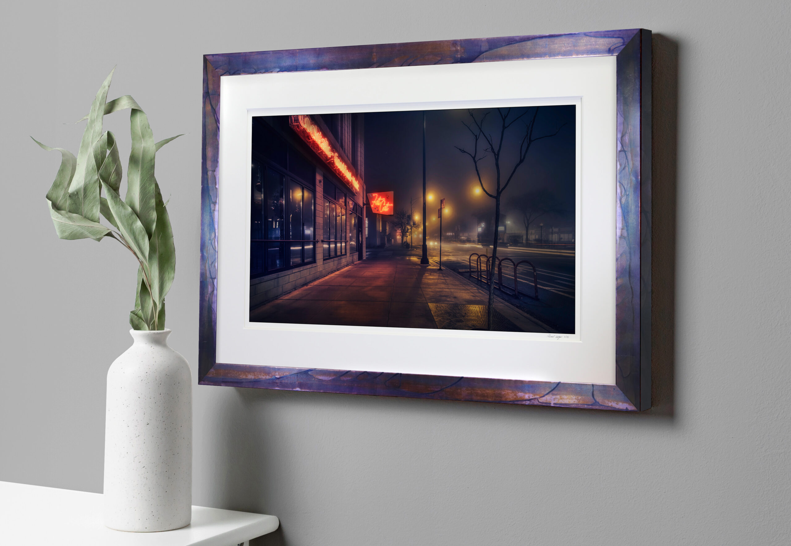 A photo of a custom framed photograph of a bar named Fat Cat on misty evening.