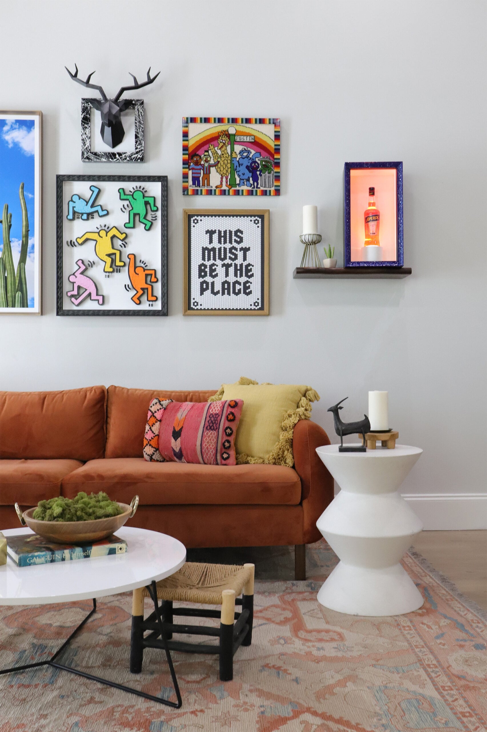 A photo of a midcentury modern living room with a unique gallery wall framed by Hall of Frames 